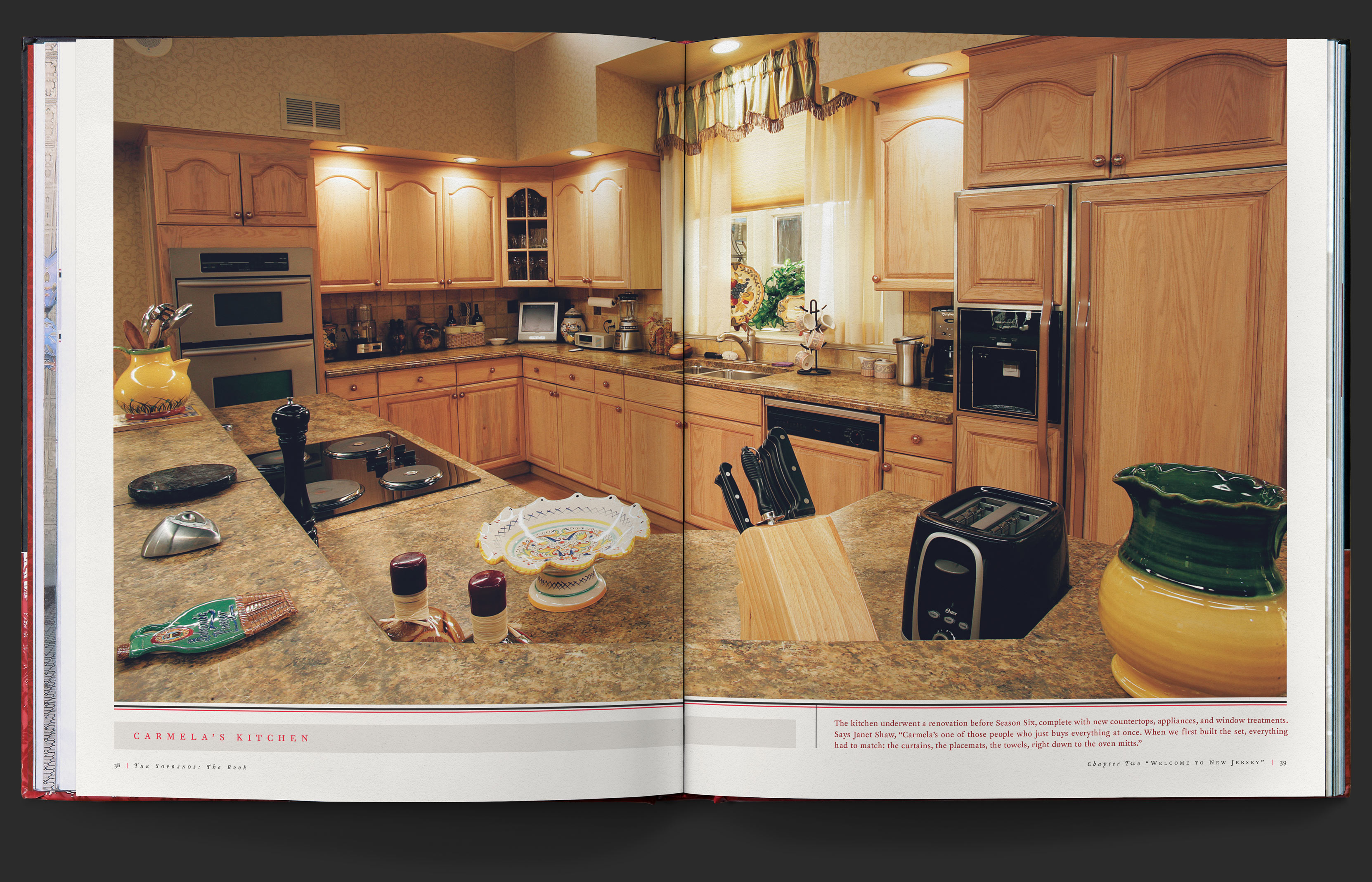 Full spread photograph of Carmela Soprano’s large kitchen, with the light wood cabinets in all their nineties glory.