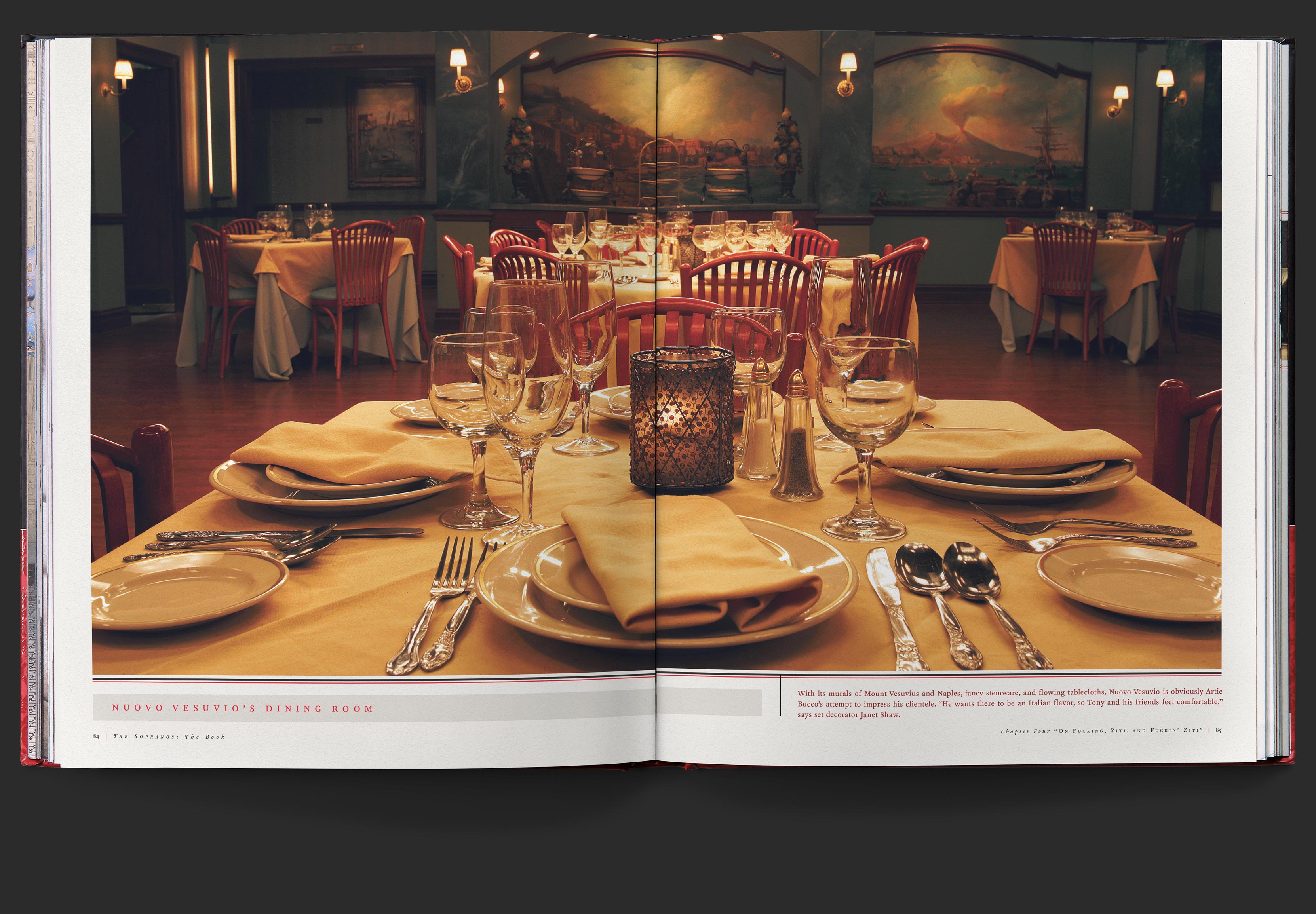 Two page photo of the Nuovo Vesuvio’s dining room, showing tables laid with dining ware amidst walls covered in murals of italian scenes.